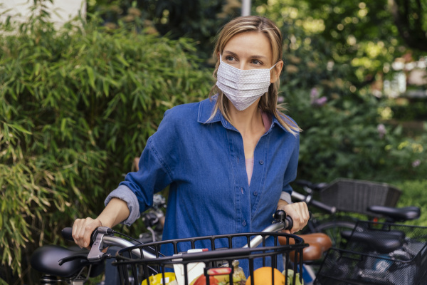 mulher usando mascara facial com bicicleta