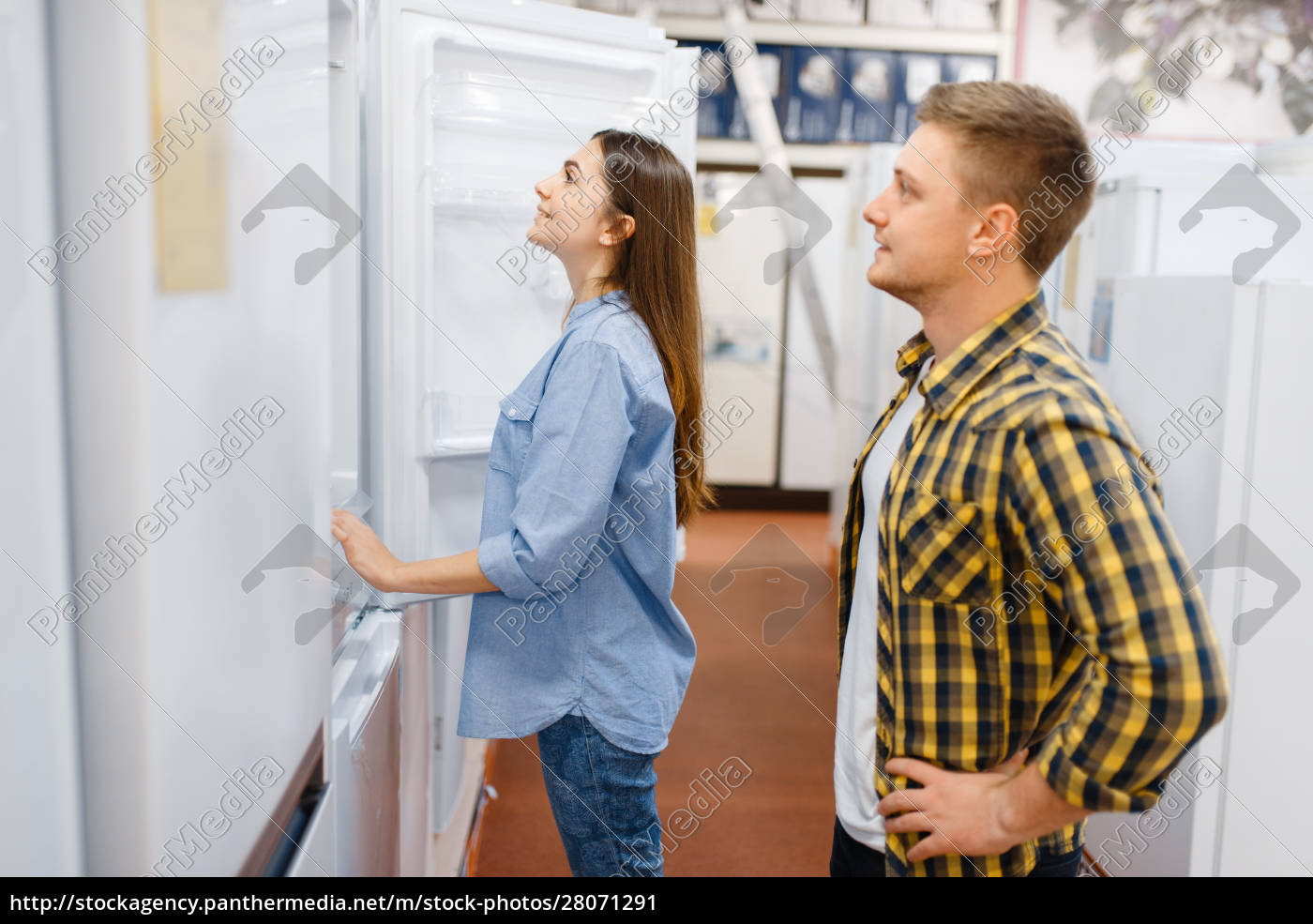 Jovem casal escolhe tv de plasma na loja de eletrodomésticos